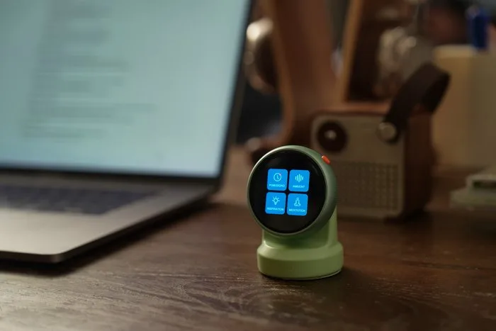 Tikpal Voice on a desk beside a laptop — present, never demanding attention